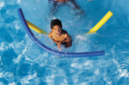Boy playing with pool floats